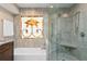 Bright bathroom featuring a tub, glass shower, and an eye-catching stained glass window at 4240 Golf Club Ln, Tampa, FL 33618