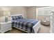 Inviting bedroom with a plaid comforter and bright natural light from shuttered windows at 4240 Golf Club Ln, Tampa, FL 33618