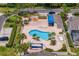 Overhead shot of a renovated community pool featuring ample lounging areas, palm trees, and shade structures at 4240 Golf Club Ln, Tampa, FL 33618