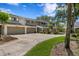 A townhome complex featuring attached garages and beautiful landscaping at 4240 Golf Club Ln, Tampa, FL 33618