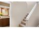 Hallway with stairway and view of a bathroom with wood cabinets at 4240 Golf Club Ln, Tampa, FL 33618