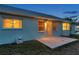 The home's rear exterior shows a back door, a patio, and window views into the warmly lit interior at 4301 Avanti Cir, New Port Richey, FL 34655