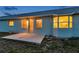 A shot of the home's rear exterior features a patio and a bay window into the warmly lit interior at 4301 Avanti Cir, New Port Richey, FL 34655