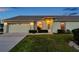 Charming home at dusk with a manicured front lawn and a two-car garage at 4301 Avanti Cir, New Port Richey, FL 34655