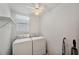 Bright laundry room with modern washer, dryer, shelving and fan light at 4301 Avanti Cir, New Port Richey, FL 34655