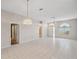Spacious living room with tile flooring, multiple doors, and bright lighting at 4301 Avanti Cir, New Port Richey, FL 34655