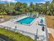 Community pool surrounded by sun loungers, umbrellas, and a covered area for relaxing by the pool at 4301 Avanti Cir, New Port Richey, FL 34655