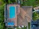 Aerial view of the community pool showing the pool, patio, sun loungers, and the building's brown roof at 4301 Avanti Cir, New Port Richey, FL 34655