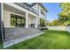 Backyard view featuring a pristine lawn, outdoor kitchen, and access to the home's interior at 481 W Davis Blvd, Tampa, FL 33606