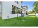 Side angle of the expansive backyard featuring artificial turf and outdoor living spaces at 481 W Davis Blvd, Tampa, FL 33606