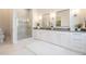 Bright bathroom showcasing dual vanities, a glass-enclosed shower, and marble flooring at 481 W Davis Blvd, Tampa, FL 33606