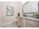 Stylish half-bathroom with wood-look vanity, modern fixtures, and decorative art at 481 W Davis Blvd, Tampa, FL 33606