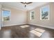 Airy bedroom with hardwood floors, ceiling fan, and multiple windows offering natural light and views at 481 W Davis Blvd, Tampa, FL 33606