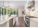 Modern white kitchen with a large island, stainless steel appliances, and sliding glass doors to outdoor views at 481 W Davis Blvd, Tampa, FL 33606