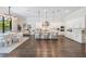 Open-concept kitchen and dining area with dark floors, white cabinets, modern lighting, and stainless appliances at 481 W Davis Blvd, Tampa, FL 33606