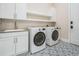 Bright laundry room with white cabinets, gray countertops, and patterned tile flooring at 481 W Davis Blvd, Tampa, FL 33606