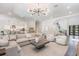 Open-concept living room with modern chandelier, comfortable seating, and seamless flow to other rooms at 481 W Davis Blvd, Tampa, FL 33606