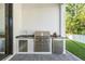 Covered outdoor kitchen featuring a stainless steel grill and built-in mini-fridge at 481 W Davis Blvd, Tampa, FL 33606