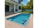 Stunning pool with built-in stools and tanning ledge, complemented by a covered patio and lush landscaping at 481 W Davis Blvd, Tampa, FL 33606