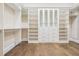 Bright walk-in closet with white shelving, glass-front cabinets, and drawers offering ample storage and style at 481 W Davis Blvd, Tampa, FL 33606
