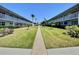 Condominium complex with well-kept lawn and tropical landscaping, showcasing a serene and inviting community atmosphere at 5227 81St Lane N # 26, St Petersburg, FL 33709