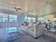 Bright and airy living room featuring a plush sofa, mirrored wall, and natural light, offering a comfortable living space at 5227 81St Lane N # 26, St Petersburg, FL 33709