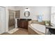Bathroom featuring a soaking tub, walk-in shower, dark cabinets, and stone countertops at 5310 Sanderling Ridge Dr, Lithia, FL 33547