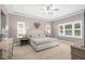 A serene bedroom with a tray ceiling, neutral tones, and plantation shutters at 5310 Sanderling Ridge Dr, Lithia, FL 33547