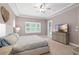 Well-lit bedroom featuring neutral walls, tray ceiling, plantation shutters, and a comfy bed at 5310 Sanderling Ridge Dr, Lithia, FL 33547