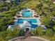 Overhead shot of a community pool and amenities surrounded by tropical landscaping, a pool house, and sun loungers at 5903 Nature Ridge Ln, Lithia, FL 33547