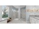 Bright bathroom featuring a glass-enclosed shower with white marble tile and a white granite countertop at 5903 Nature Ridge Ln, Lithia, FL 33547