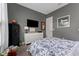 Cozy bedroom featuring a white dresser, dark gray walls, patterned bedding, and a wall-mounted television at 5903 Nature Ridge Ln, Lithia, FL 33547