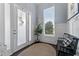 Bright foyer features a frosted-glass entry door, natural light, bench, and a neutral color scheme at 5903 Nature Ridge Ln, Lithia, FL 33547