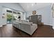 Large living room area with vaulted ceiling, dark hardwood floors, gray sectional couch, and backyard access at 5903 Nature Ridge Ln, Lithia, FL 33547