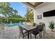 An outdoor dining table sits on a paver patio with a pool and lush landscaping at 5903 Nature Ridge Ln, Lithia, FL 33547