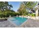 A sparkling pool and spa are surrounded by lush landscaping and stone pavers at 5903 Nature Ridge Ln, Lithia, FL 33547