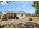 Backyard view with a covered patio, wooden fence, and an open fire pit at 6416 Lomand Ave, New Port Richey, FL 34653