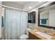 Bathroom features a wood vanity and shower with a blue patterned shower curtain at 6416 Lomand Ave, New Port Richey, FL 34653