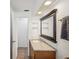 Bathroom featuring a wood vanity with granite countertop and a large mirror at 6416 Lomand Ave, New Port Richey, FL 34653
