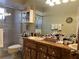 Bright bathroom with vanity, dual sinks, framed mirrors, and tiled shower enclosure at 6703 Peachtree Dr, Temple Terrace, FL 33617