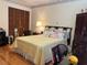 Cozy bedroom with a bright yellow quilt, hardwood floors, and a classic, decorative border at 6703 Peachtree Dr, Temple Terrace, FL 33617