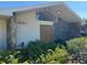 Home exterior featuring a distinctive stone facade and lush fern landscaping at 6703 Peachtree Dr, Temple Terrace, FL 33617