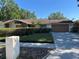 Charming single-story home with a well-kept lawn, a two-car garage, and stone architectural details at 6703 Peachtree Dr, Temple Terrace, FL 33617