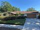 Charming single-story home with a well-kept lawn, a two-car garage, and stone architectural details at 6703 Peachtree Dr, Temple Terrace, FL 33617