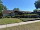 Well-maintained single-story home featuring a manicured lawn and mature landscaping at 6703 Peachtree Dr, Temple Terrace, FL 33617