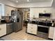 Well lit kitchen offering stainless appliances, white cabinets and black granite countertops at 6703 Peachtree Dr, Temple Terrace, FL 33617