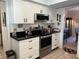 Kitchen features white cabinets, stainless steel appliances, and black countertops at 6703 Peachtree Dr, Temple Terrace, FL 33617
