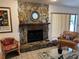 Cozy living room with a stone fireplace, comfortable seating, and natural light at 6703 Peachtree Dr, Temple Terrace, FL 33617