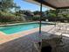 Backyard pool area with brick paver decking, a covered patio, and lush landscaping at 6703 Peachtree Dr, Temple Terrace, FL 33617