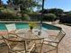 Relaxing pool area with a table and chairs, perfect for outdoor entertaining at 6703 Peachtree Dr, Temple Terrace, FL 33617